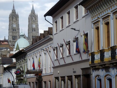 Colonial street building facades with national flags looking towards the Basilica del Voto Nacional, Quito, Ecuador