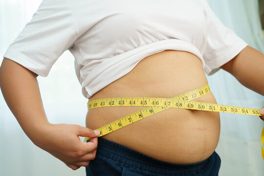 Asian woman use hand to squeeze fat belly big size overweight and obesity.