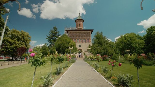 The Church of Saint Nicholas the Prince in Iasi. The camera focuses on the church surrounded by green gardens and urban scenery on a sunny day.