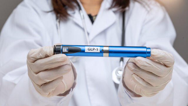Confident doctor holding blue medical injection pen offers hopeful weight management therapy for healthy adult patient care