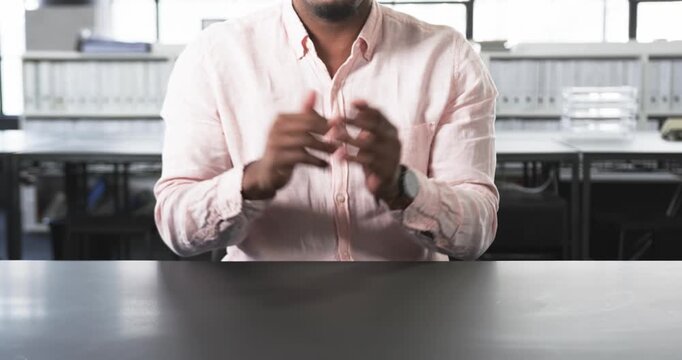 Close up of people talking to the camera, businessman in pink shirt gesturing with hands while sitti