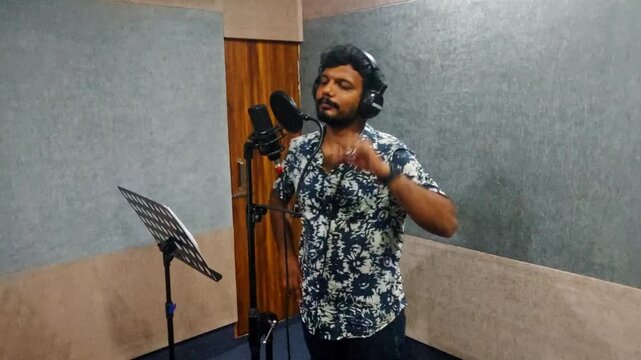 Male Voice Actor Adjusting Microphone Pop Filter During Dubbing Session in Sound Studio at hyderabad, telangana, india. internal shot, hand held shot, 4k.