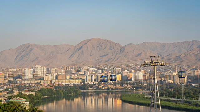 Scenic cityscape view of Syr Darya river in Khujand city with cable car and Mogoltau mountains at sunrise, Sughd, Tajikistan