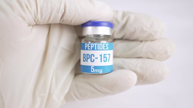 Scientist in a latex glove presenting a vial of BPC 157 peptide isolated on a white background