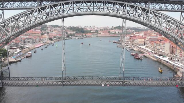 Aerial: Ascending drone shot from the lower deck to the upper deck of Dom Luis I Bridge, Porto, Portugal