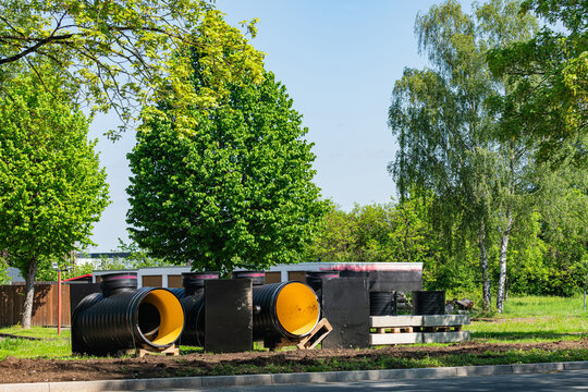 Construction materials are arranged on a site near trees