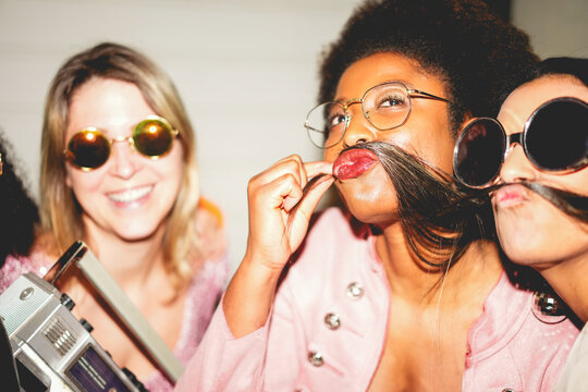 Group of multiracial girls dancing, drinking champagne and listening music outdoor - Party, summer and street nightlife concept - Focus on afro woman mouth - UGC flash content