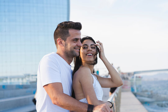 Happy young couple standing by the sea