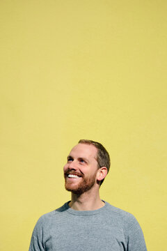 Portrait of laughing young man in front of yellow background