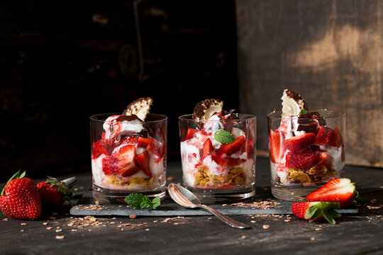 Dessert in glasses with yoghurt, curd, strawberries, chocolate chips and chocolate marshmallow
