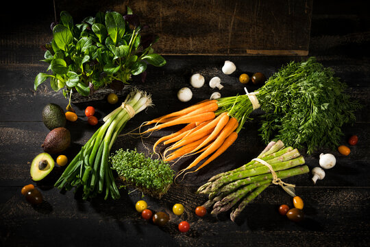 Various organic vegetables on dark wood