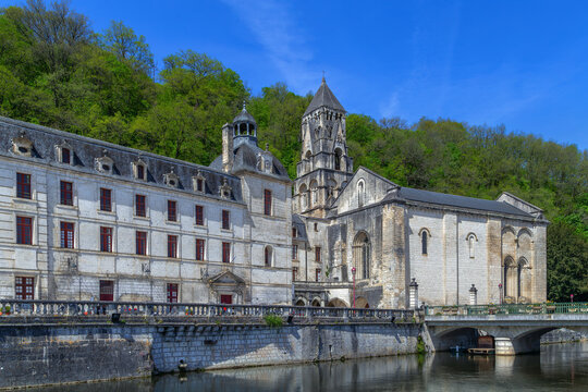 Abbey of Brantome and its bell tower, France, view from the river. Historical benedictine monastery with reflection