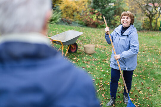 Senior couple enjoys autumn cleanup in home garden