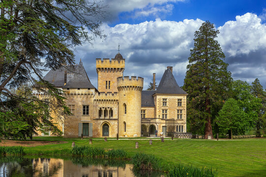 Chateau de Campagne, France, scenic view from the pond. Historical medieval stone castle with water reflection