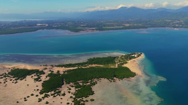 Aerial view of Cowrie Island featuring lush greenery, sandy beaches, and turquoise waters surrounded by the vast ocean in Puerto Princesa City, Mimaropa, Philippines.
