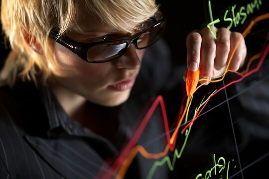 Businesswoman drawing glowing financial growth charts on a transparent glass board in office