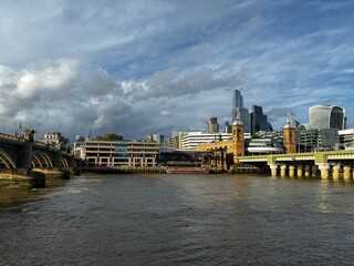 Fototapeta premium London city skyline over River Thames featuring Southwark Bridge and 20 Fenchurch Street skyscraper under dramatic clouds, UK.