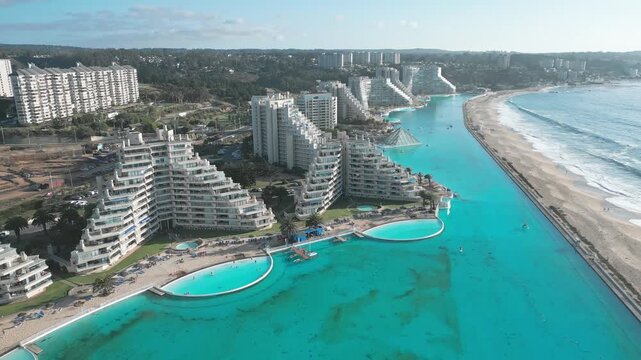 Aerial view of the San Alfonso del Mar resort featuring its massive turquoise swimming pool and modern apartment buildings along the coastline in Algarrobo, Valparaiso, Chile.