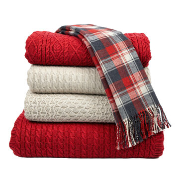 Stack of folded red and beige cable knit sweaters with a plaid scarf isolated on a transparent background