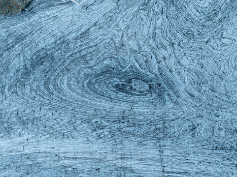 Aerial view of wood grain texture with intricate swirling patterns and natural lines in Valmalenco, Lombardia, Italy.