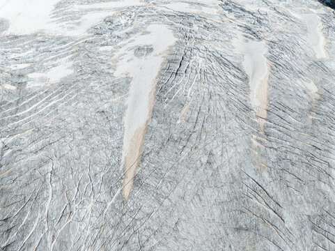 Aerial view of the deep crevasses and textured ice formations of the Ghiacciaio del Rutor in La Thuile, Aosta Valley, Italy.