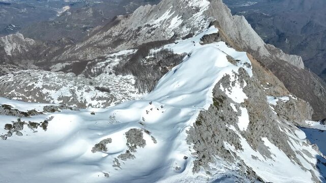 Aerial view of the snow-covered Pania della Croce mountain peak with rocky ridges and deep valleys in Stazzema, Tuscany, Italy.