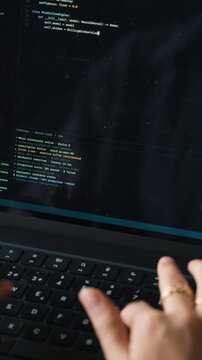 Female software engineer coding on laptop computer
