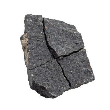 A fragmented piece of dark grey volcanic basalt rock with visible cracks and rough texture isolated on a transparent background