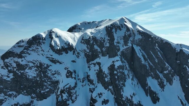 Aerial view of the snow-covered Pania della Croce mountain peak with rugged rocky cliffs in Stazzema, Tuscany, Italy.