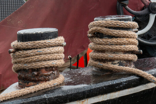 Rope tied around mooring posts at a dock during a cloudy day