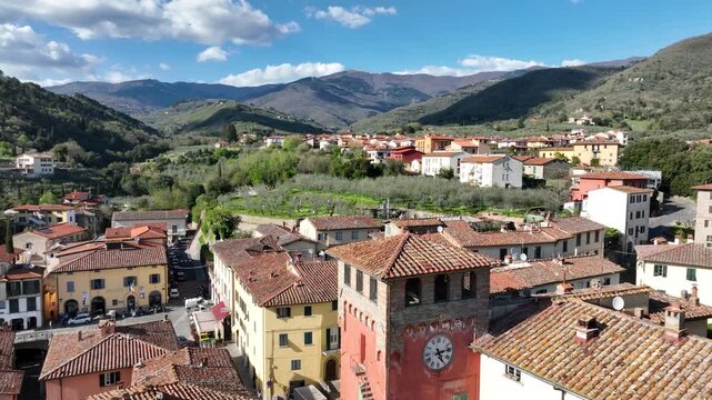 Aerial view of the historic village of Loro Ciuffenna with its terracotta rooftops, clock tower, and surrounding hills in Loro Ciuffenna, Tuscany, Italy.