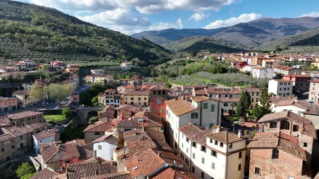 Aerial view of Loro Ciuffenna with its historic clock tower and terracotta rooftops nestled among the rolling hills of Tuscany, Loro Ciuffenna, Tuscany, Italy.