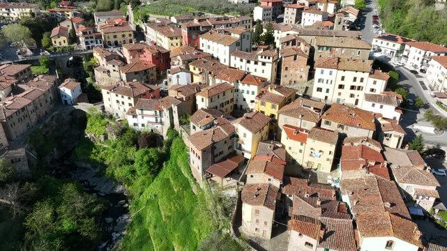 Aerial view of the historic village of Loro Ciuffenna with stone buildings and lush greenery in Loro Ciuffenna, Tuscany, Italy.