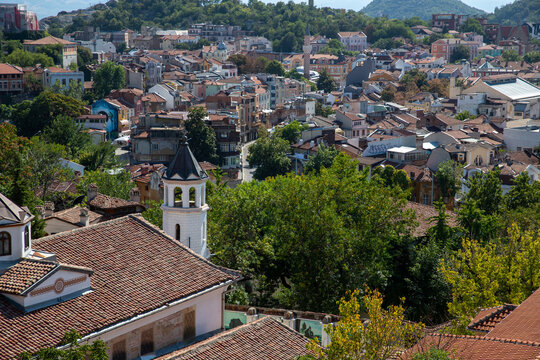 Plovdiv, Plovdiv Province, Bulgaria - 24 August 2018: View of the historic Old Town with traditional architecture, terracotta rooftops, and a church tower under a clear sky.