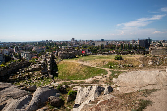 Plovdiv, Bulgaria - 24 August 2018: View of the ancient ruins of Nebet Tepe overlooking the modern cityscape of Plovdiv under a clear blue sky.