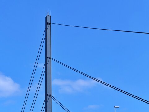 Abstract Low-Angle Detail of a Modern Cable-Stayed Bridge Pylon with Tension Cables Against Blue Sky