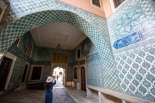Istanbul,turkey,august 3, 2025. Tourist photographing the beautiful iznik tiles and islamic calligraphy decorating the walls and archway inside the topkapi palace harem