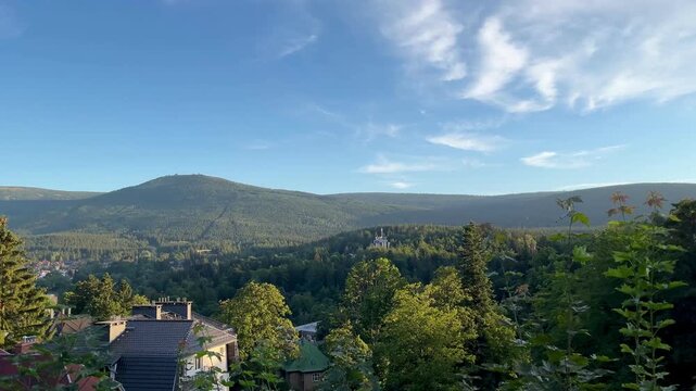 Panoramic view of the Karkonosze and Sudetes Mountains near Szklarska Poręba in Poland, with forested ridges and distant settlements in 4k footage. Concept of mountain travel, escape, perspective.