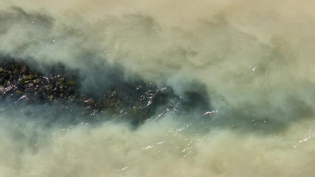 Aerial view of a glacial river with sediment flowing through the landscape in Hallormsstadur, Mulathing, Iceland.