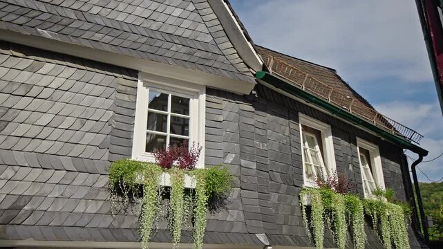 Slate-Clad House Facade with Flower Boxes in Freudenberg