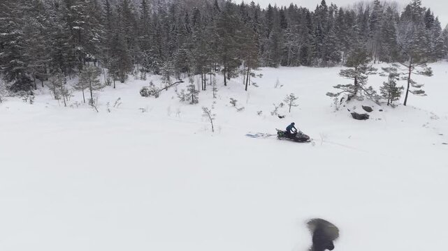 Snowmobile On A Cross-country Ski Tracks Across A Snow-covered Winter Landscape In Norway. Aerial Tracking Shot