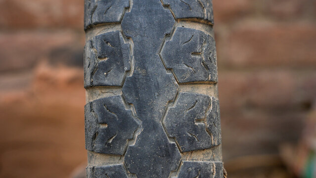 Close up of a worn motorcycle tire tread pattern with textured rubber surface
