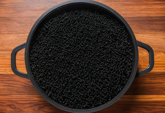 Food waste and overconsumption concept, black textured food in a cooking pot on a wooden table, culinary experimentation and unusual ingredients