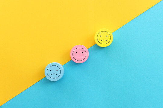 Top view image of wooden cubes with of happy and sad face. concept of happiness emotion and satisfaction