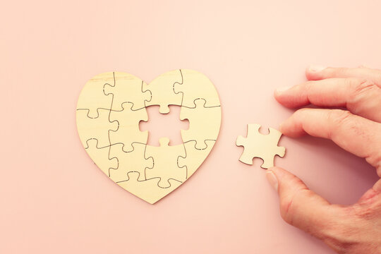 Heart shape puzzle on pastel pink background