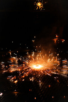 Sparkling Ground Chakra Firework Spinning on Floor in Dark Night; Diwali Festival Celebration with Golden Bright Firecracker Sparks Long Exposure Motion Blur, Spectacular Pyrotechnic Photography