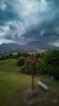 Vertical Hyperlapse Approaching Christian Cross Under Stormy Sky