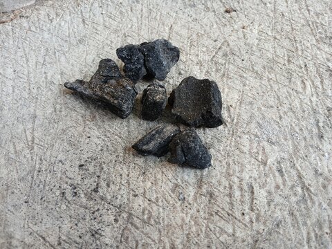 Small pieces of natural wood charcoal on rough concrete background