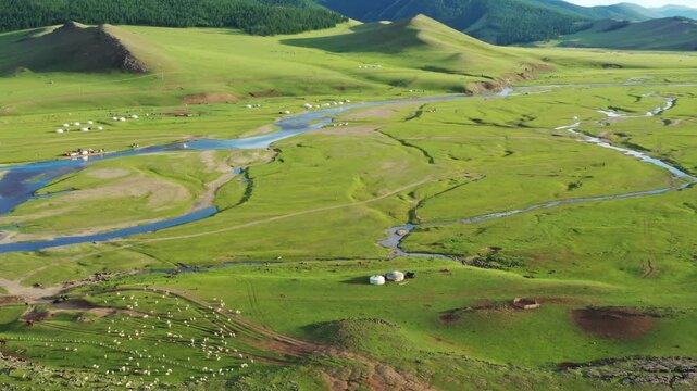 Aerial view of Orkhon Valley Natural and Historical Reserve with winding river, green pastures, and traditional gers in Xarxorin, Ovorkhangai, Mongolia.