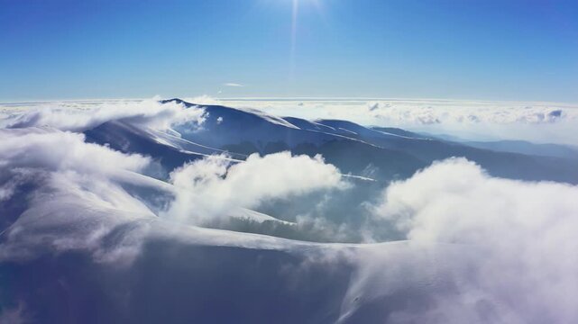 An extraordinary mountain valley covered with fluffy clouds at winter sunset